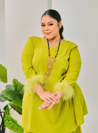 A woman dressed in Pucuk Pisang Tun Malika Feather Wrap Kurung