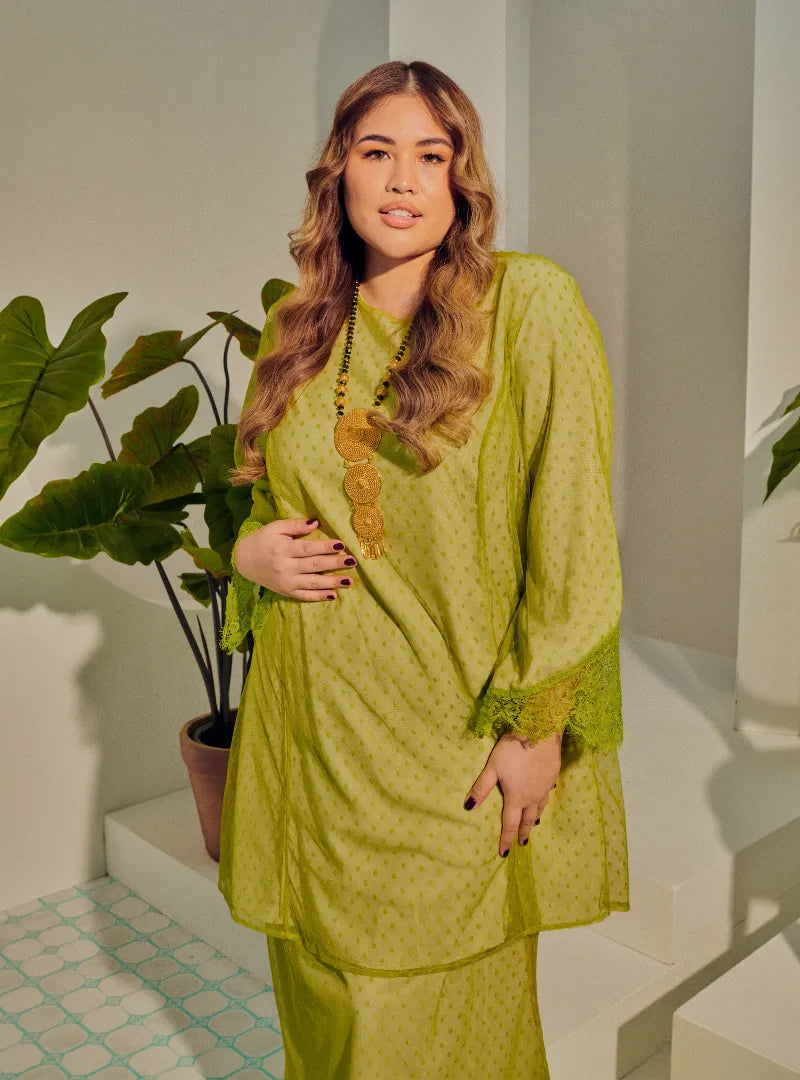 A woman dressed Pucuk Pisang Tun Melur Dotted Kurung Pahang-