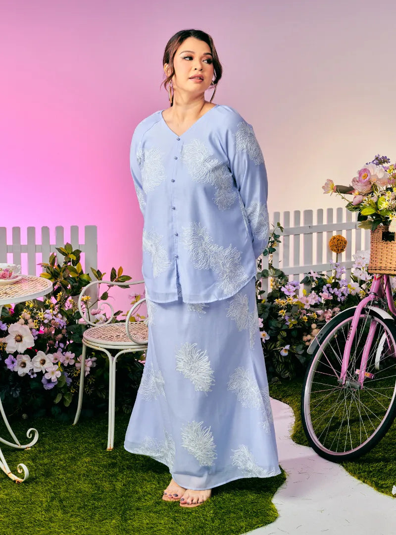 A woman dressed in Purple Blue Tun Iman Mandarin Kurung