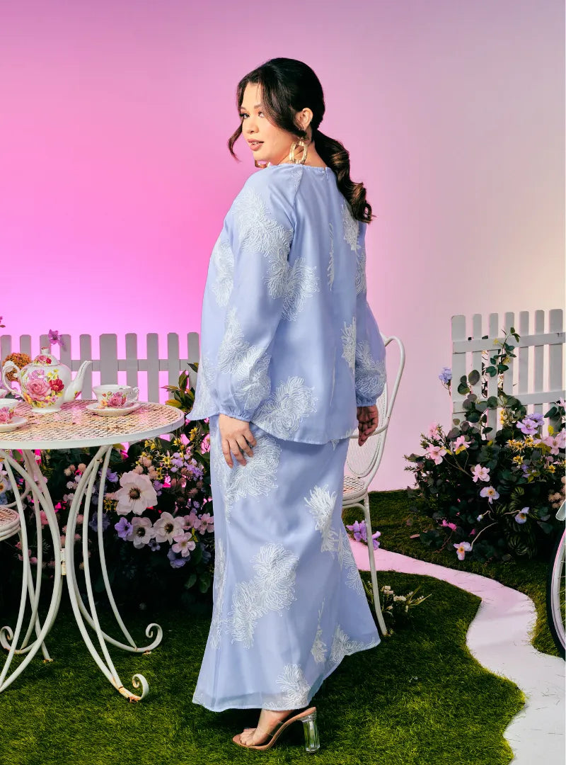 A woman dressed in Purple Blue Tun Iman Mandarin Kurung