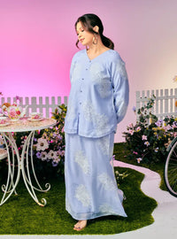 A woman dressed in Purple Blue Tun Iman Mandarin Kurung