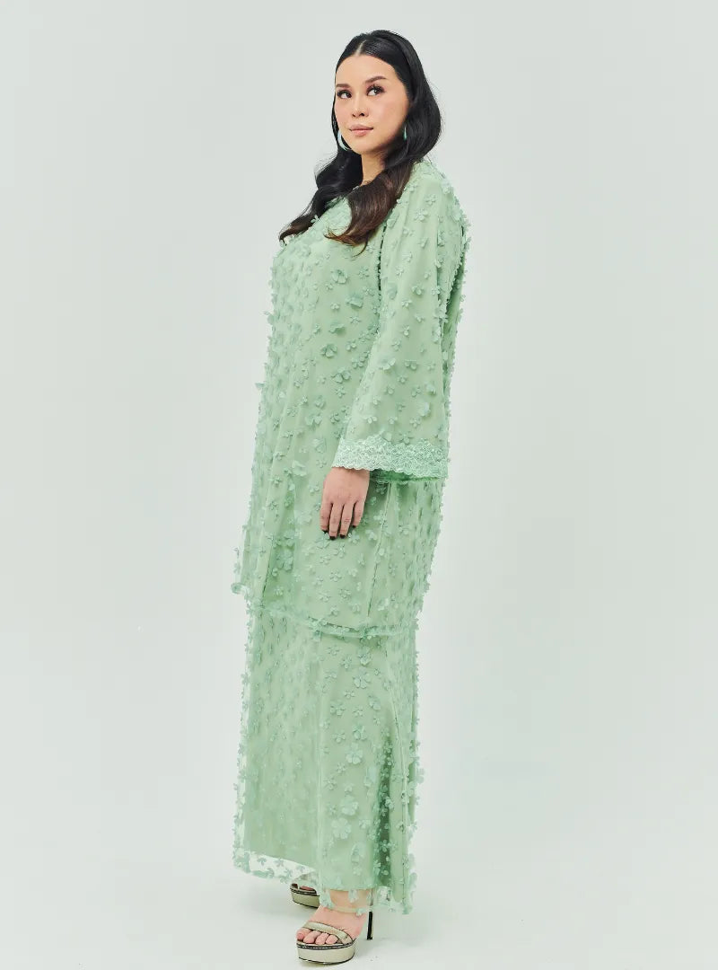 A woman dressed in Sage Green Tun Sharifah Lace Kurung