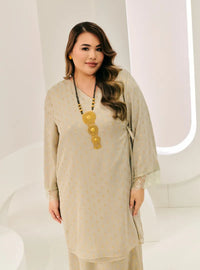 A woman dressed in Sage Tun Tipah Dotted Wrap Kurung