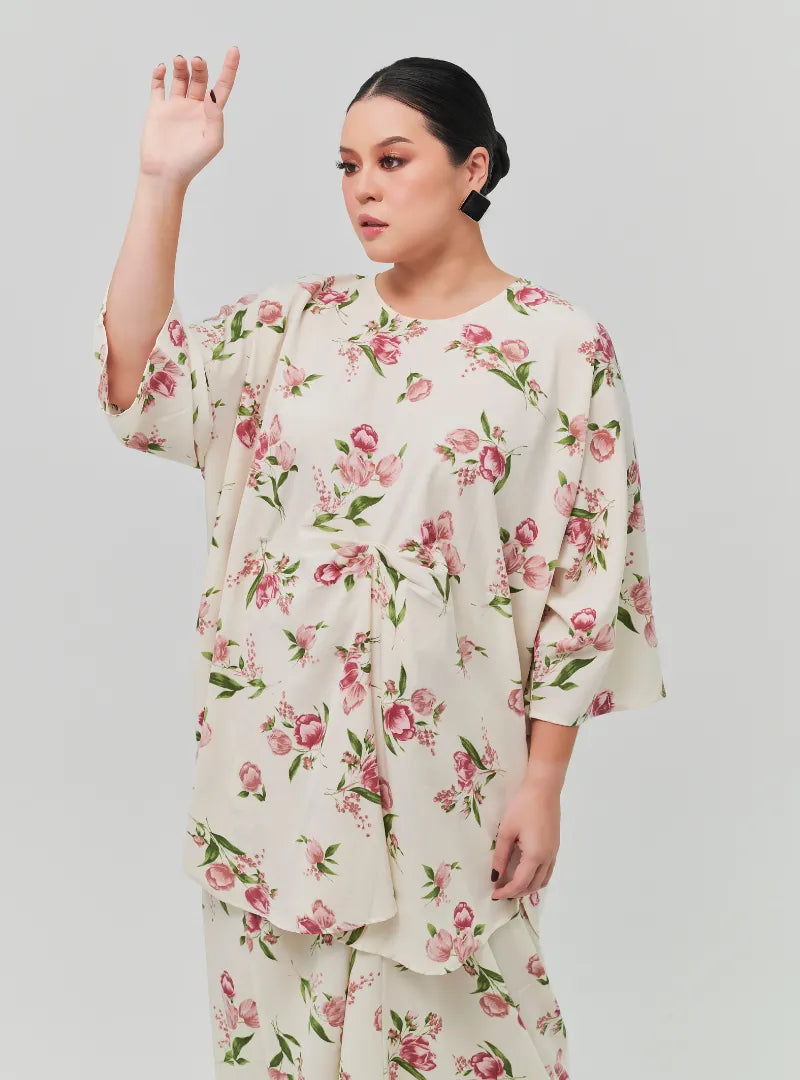 A woman dressed in Sand Lily The Vintage Opah Kurung