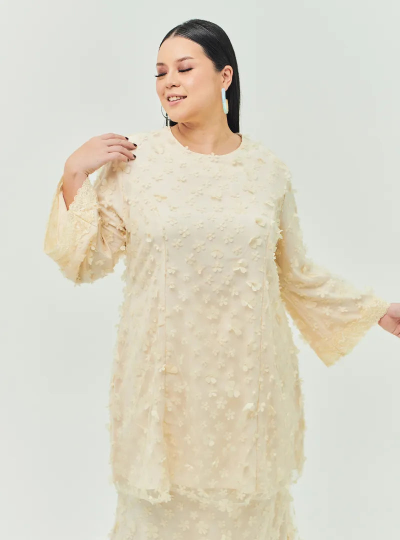 A woman dressed in Sand Tun Sharifah Lace Kurung