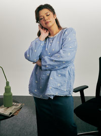 A woman dressed in Stone Blue Arya Peplum Embroidered Top