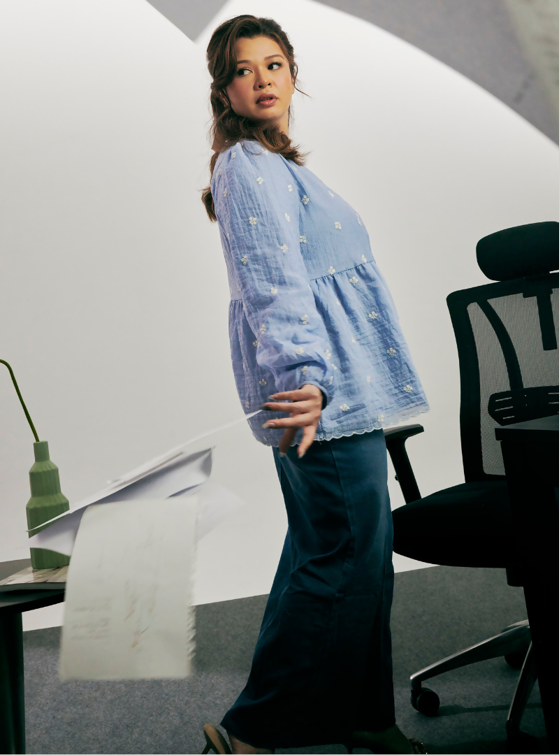 A woman dressed in Stone Blue Arya Peplum Embroidered Top