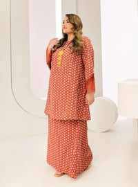 A woman dressed in Tangerine Tun Maryam Eyelet Kurung