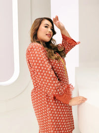 A woman dressed in Tangerine Tun Maryam Eyelet Kurung