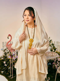 A woman dressed in Sand Champagne Tun Seroja Satin Kurung Pahang