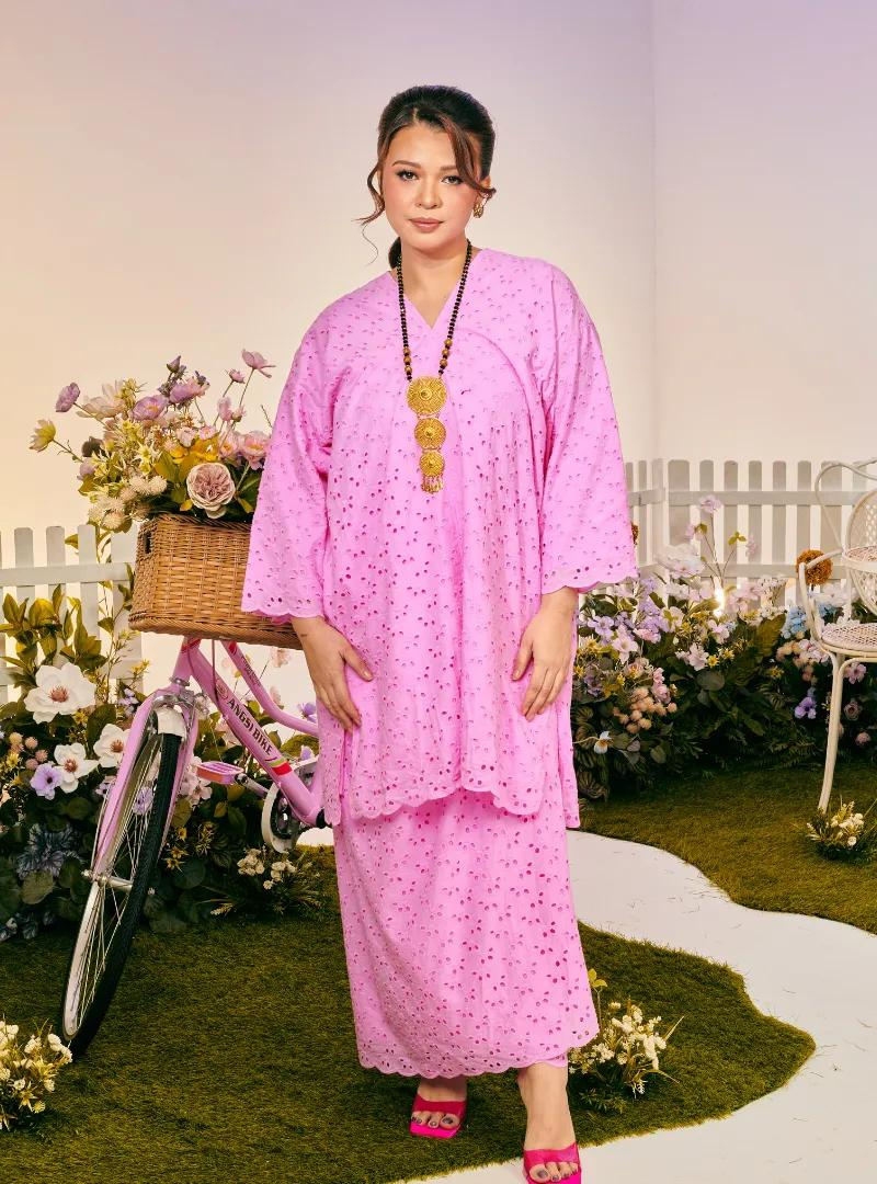 A woman dressed in Pink Doll Tun Yasmin Embroidered Eyelet Oversized Kurung