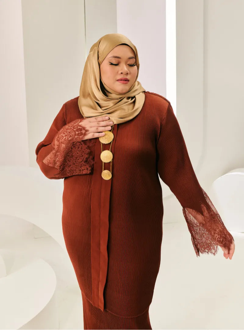 A woman dressed in Walnut Tun Jamilah Pletated Kebarung