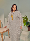 A woman dressed in White Checked Tun Zainab Vintage Checked Kurung