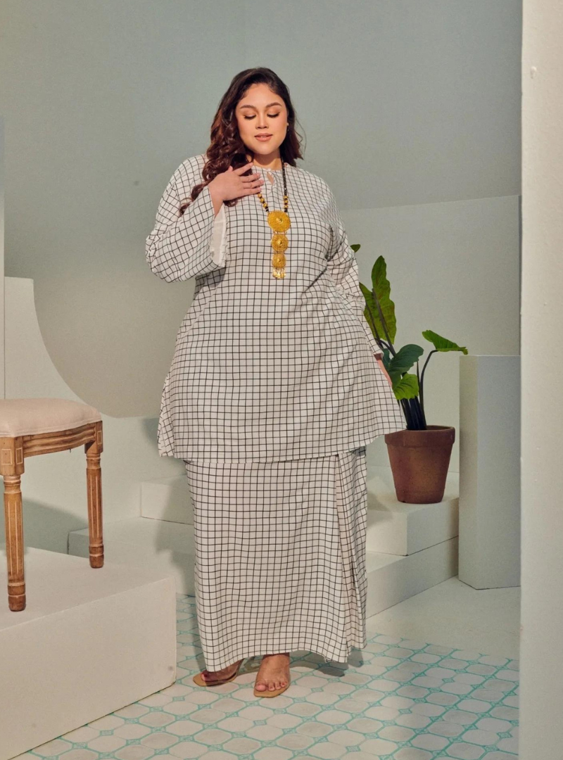 A woman dressed in White Checked Tun Zainab Vintage Checked Kurung