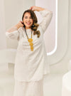 A woman dressed in White Tun Huda Eyelet Kurung