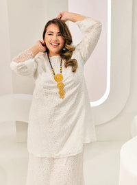 A woman dressed in White Tun Huda Eyelet Kurung