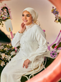 A woman dressed in White Tun Iman Mandarin Kurung