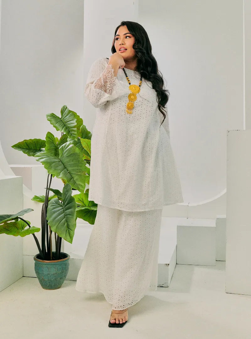 A woman dressed in White Tun Inna Kurung