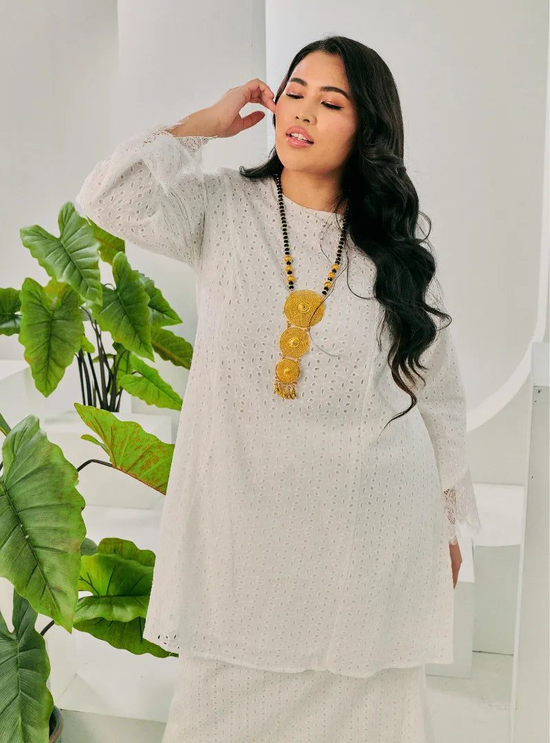 A woman dressed in White Tun Inna Kurung