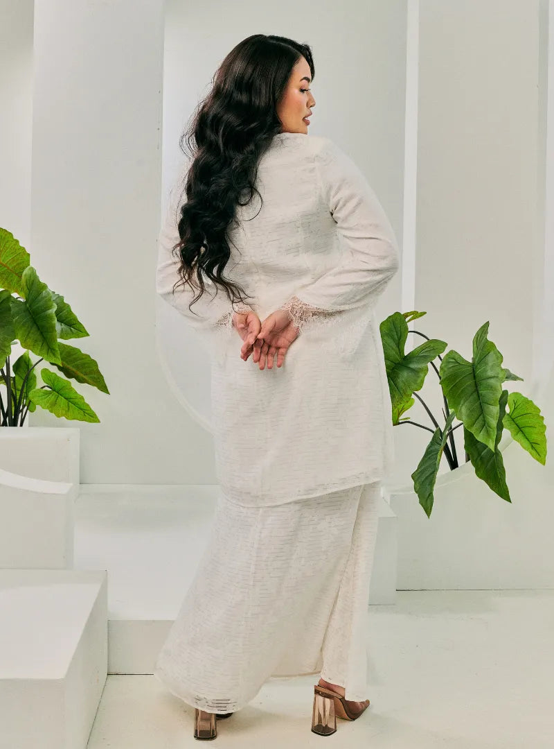 A woman dressed in White Tun Kuntom Cotton Lace Kurung