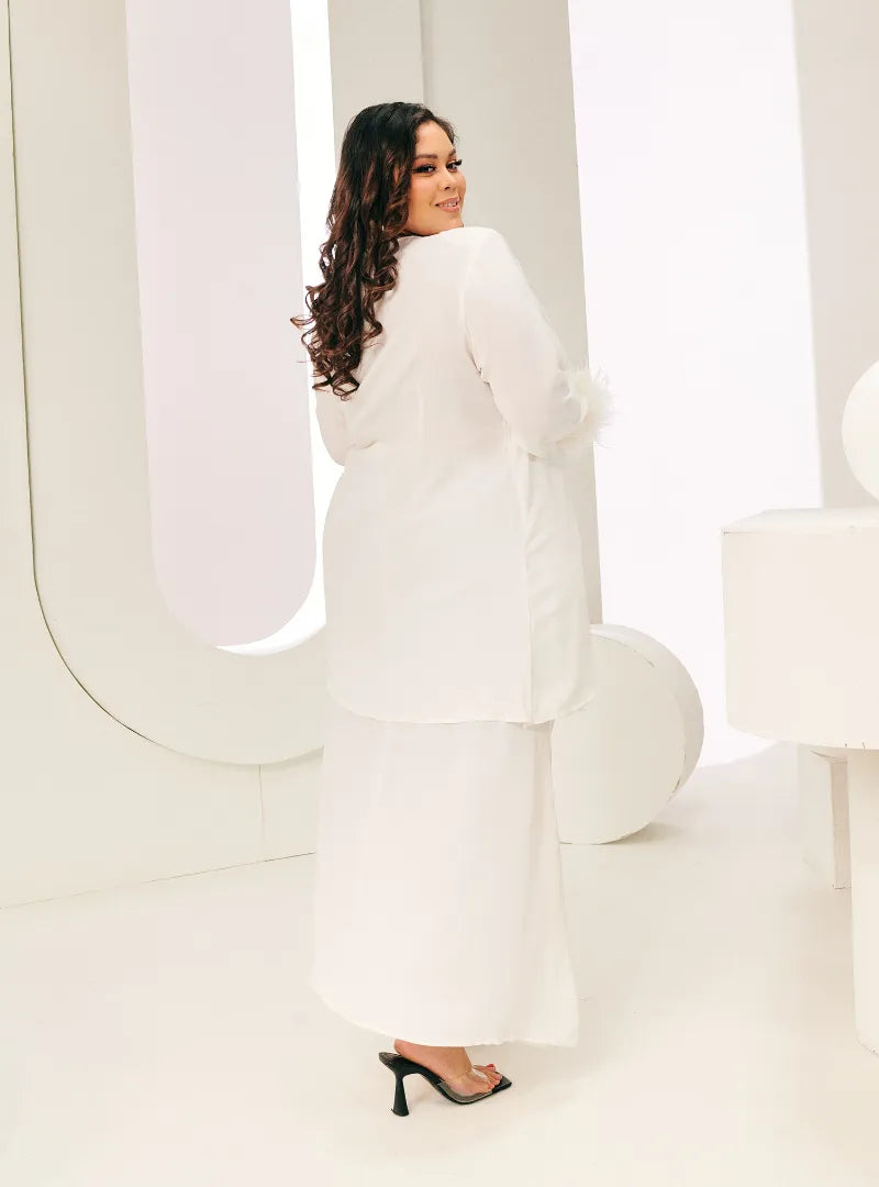 A woman dressed in White Tun Malika Feather Wrap Kurung