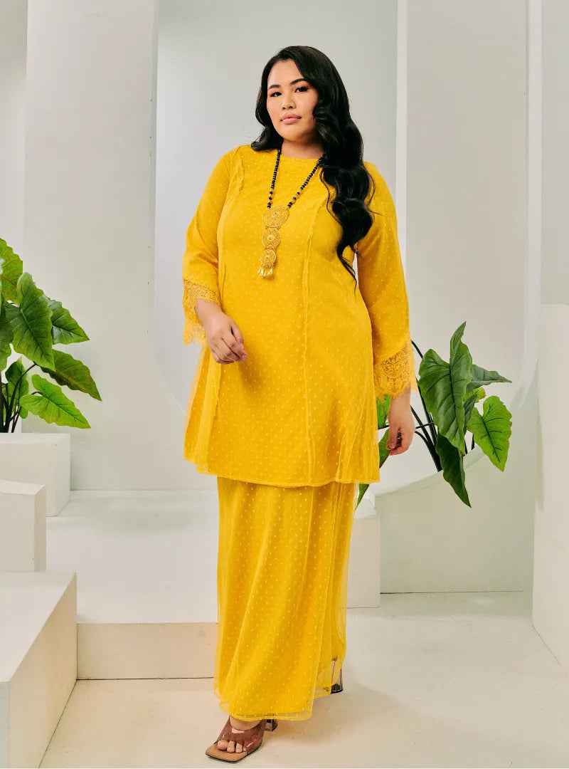 A woman dressed Yellow Tun Melur Dotted Kurung Pahang-